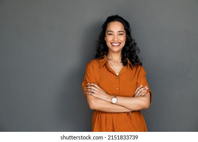 Portrait Of A Young Latin Woman With Pleasant Smile And Crossed Arms Isolated On Grey Wall With Copy Space Beautiful Girl With Folded Arms Looking At Camera Against Grey Wall Cheerful Hispanic Woman