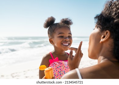 Young Mother Applying Protective Sunscreen On Daughter Nose At Beach With Copy Space Black Woman Hand Putting Sun Lotion On Female Child Face African American Cute Little Girl With Sunblock Cream