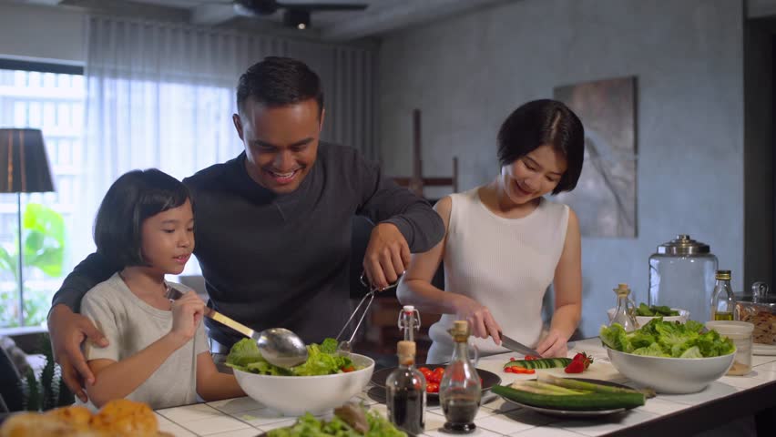 Happy Asian Family Preparing Food In The Kitchen