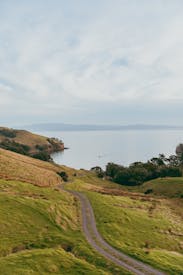 A Scenic Road Winding Through A Lush Green Hillside