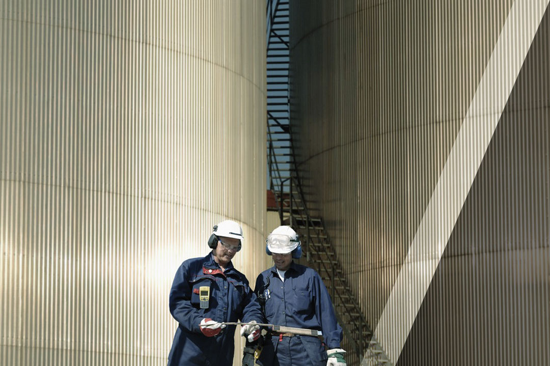 Workers in front of storage tanks