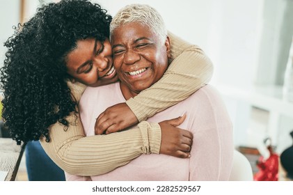 African Daughter Hugging Her Mum Indoors At Home   Main Focus On Senior Mother Face   Mom Day And Family Love Concept