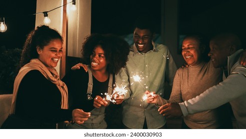 African Family Having Fun Hugging Each Other And Celebrate During New Years Eve With Firework Sparkler   Holidays And Vacation Concept   Soft Focus On Mother Face