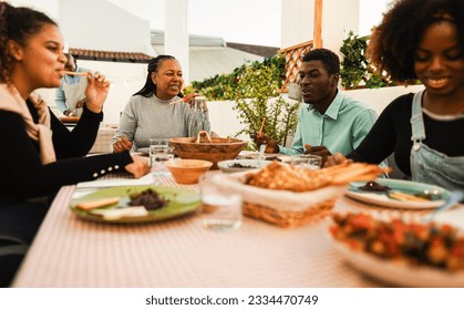 Happy African Family Having Dinner At Home Rooftop Terrace Outdoor   Summer Food And Lifestyle Concept   Main Focus On Mother Face