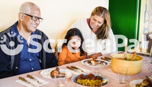 Happy Latin Child Having Fun Eating With Her Grandparents At Home   Holidays And Family Lifestyle Concept   Focus On Grandmother Face