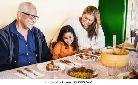 Happy Latin Child Having Fun Eating With Her Grandparents At Home   Holidays And Family Lifestyle Concept   Focus On Grandmother Face