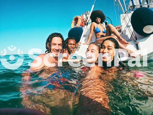 Happy Multiracial Friends Doing Selfie Swimming In The Sea With Sail Boat In Background   Soft Focus On Center Girl Face   Summer And Travel Concept