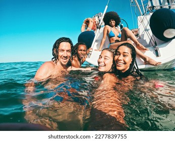 Happy Multiracial Friends Doing Selfie Swimming In The Sea With Sail Boat In Background   Soft Focus On Center Girl Face   Summer And Travel Concept