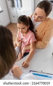 Medicine Healthcare And Pediatry Concept   Mother With Little Daughter And Doctor With Stethoscope At Clinic