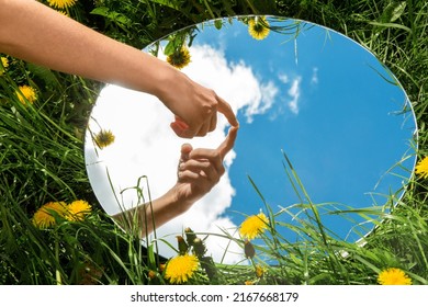 Nature Concept   Hand Touching Sky Reflection In Round Mirror On Summer Field