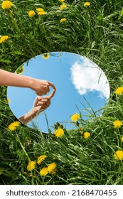 Nature Concept   Hand Touching Sky Reflection In Round Mirror On Summer Field