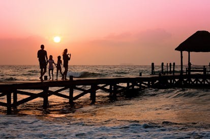 People Standing On Dock During Sunrise