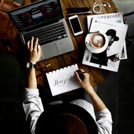 Person Sitting Facing Laptop Computer With Sketch Pad