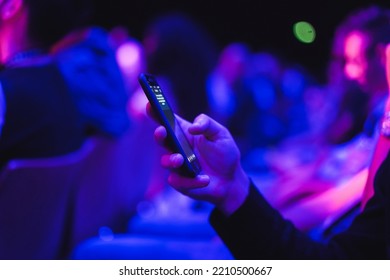 Young Man Using Mobile Phone At Technology Meeting Event   Soft Focus On Front Fingers